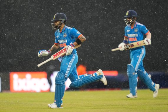 L'Indiano Virat Kohli, a sinistra, e KL Rahul corrono ai ripari mentre piove