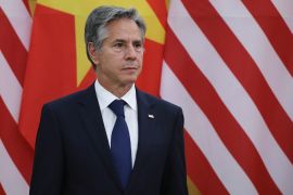 US Secretary of State Antony Blinken stands in front of an American and Chinese flag during a press conference.