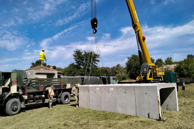 This image released by the Romanian Ministry of Defense (MAPN), shows members of the army's engineering units building concrete shelters in the village of Plauru, on the Danube river border between Romania and Ukraine on Tuesday, Sept. 12, 2023. In the Danube village of Plauru, which is situated opposite Ukraine's Danube port of Izmail, Romania's defense ministry has erected prefabricated concrete shelters for residents, measuring 9.6 meters long, 2 meters wide inside, and 1.5 meter high (about 31 feet long, 6.5 feet wide and 5 feet high). (Romanian Defense Ministry MAPN via AP)