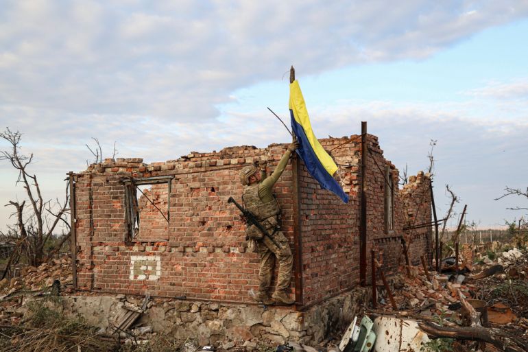 An assault unit commander from the 3rd Assault Brigade who goes by the call sign 'Fedia' raises the Ukrainian flag as a symbol of liberation of the frontline village of Andriivka, Donetsk region, Ukraine, Saturday, Sept. 16, 2023. The 3rd Assault Brigade announced Friday they had recaptured the war-ravaged settlement which lies 10 kilometers (6 miles) south of Russian-occupied city of Bakhmut, in the country's embattled east. (AP Photo/Alex Babenko)