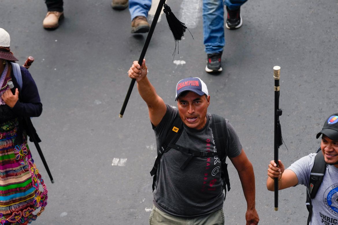 An Indigenous protester raises a staff as demonstrators march through the streets of Guatemala City on September 18.
