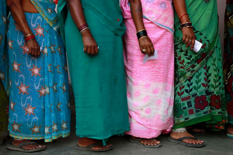 women wait to vote in India