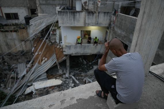 Palestinians inspect a building damaged in an Israeli army raid in Nour Shams refugee camp in the northern West Bank