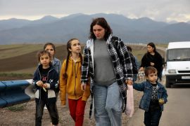 Ethnic Armenians from Nagorno-Karabakh walk along the road from Nagorno-Karabakh to Kornidzor in the Syunik region of Armenia. [Vasily Krestyaninov/AP Photo]