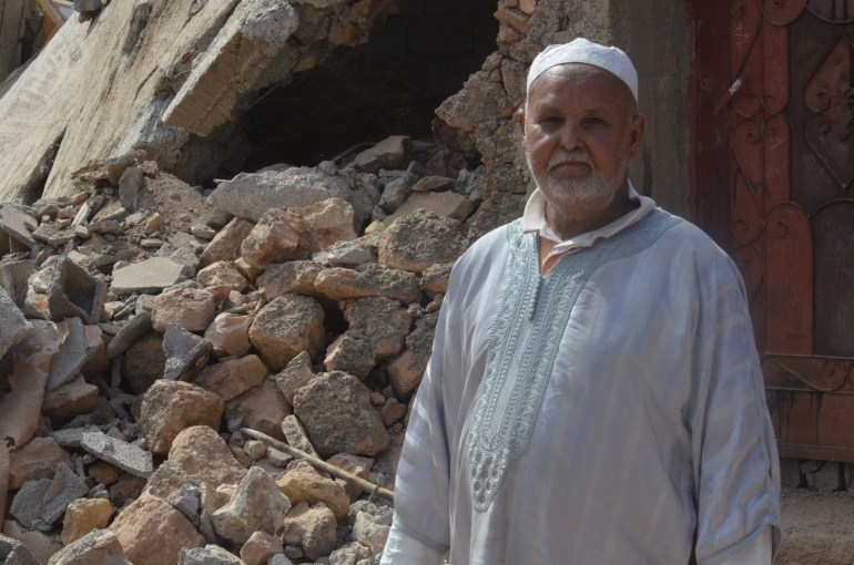 Un homme se tient devant les décombres de son ancienne maison.