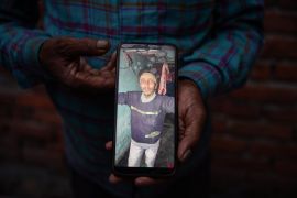 Abdul Wajid shows a photo of his son on his mobile phone [Meer Faisal/Al Jazeera]