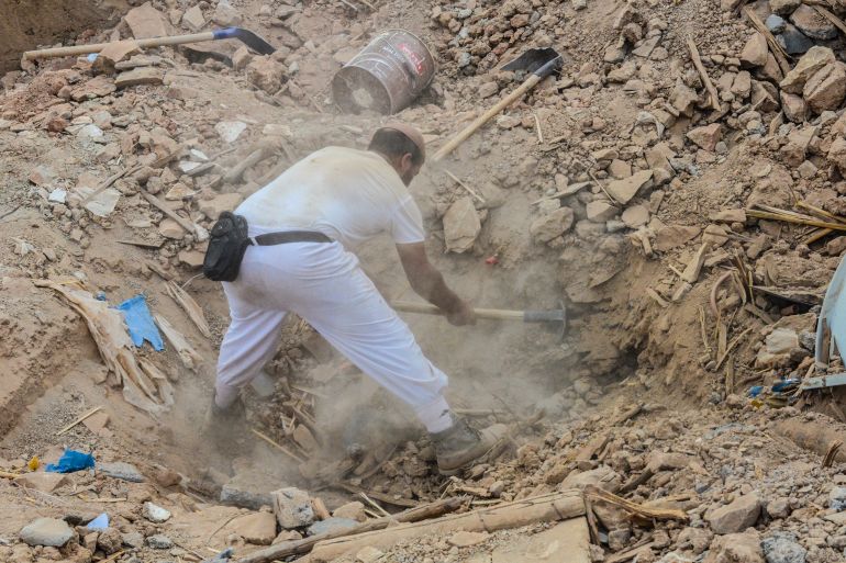 A rescuer digs through the rubble to search for Shamia, a young girl missing since the September 8 earthquake