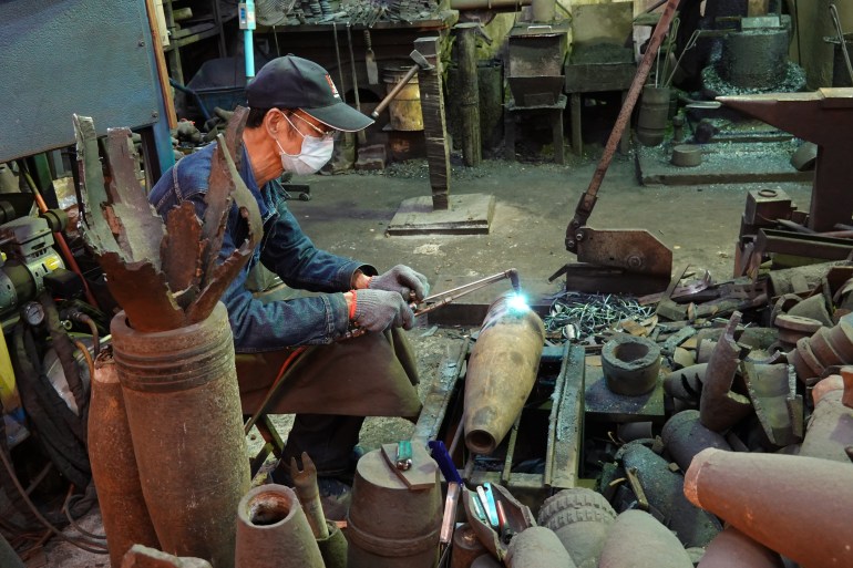 A photo of Wu working on an artillery shell.