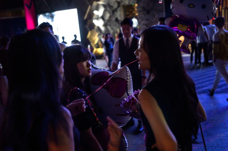 Las mujeres sostienen globos como regalo en la entrada de un club nocturno en Beijing durante el Día de San Valentín chino, el 20 de agosto de 2015. El Día de San Valentín chino es el séptimo día del séptimo mes lunar en el calendario chino y también se llama Festival Chino del Doble Siete. .  FOTO AFP / FRED DUFOUR