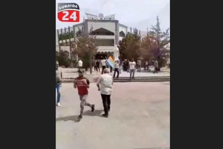 People run away during a protest in Sweida
