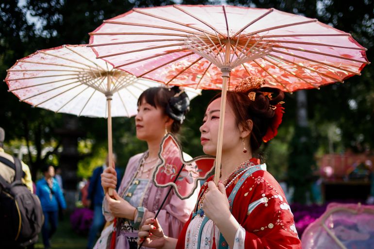 Chinese women dressed in traditional hanfu and holding tradiitional umbrellas