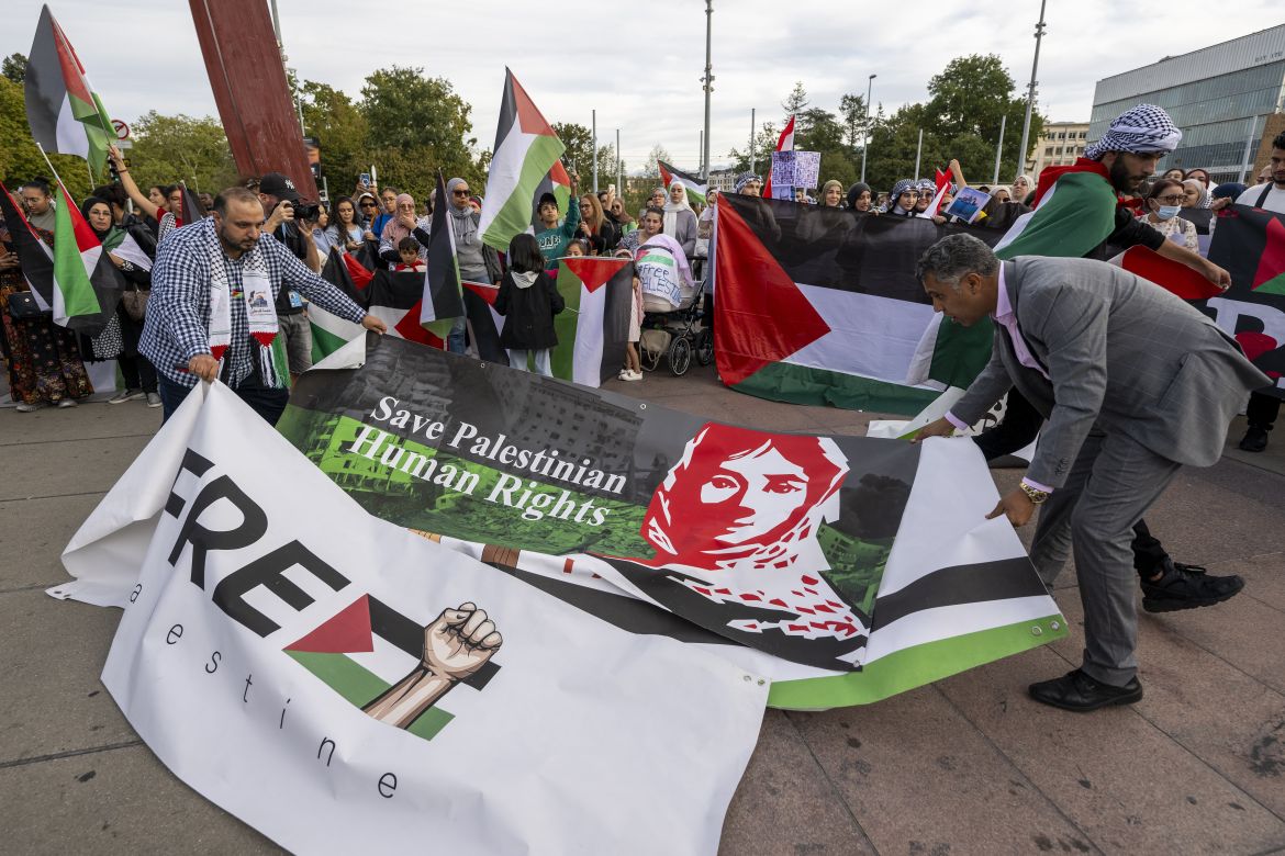 Protesters show banners as they take part in a rally in support of Palestinians, in front of the United Nations European headquarters in Geneva
