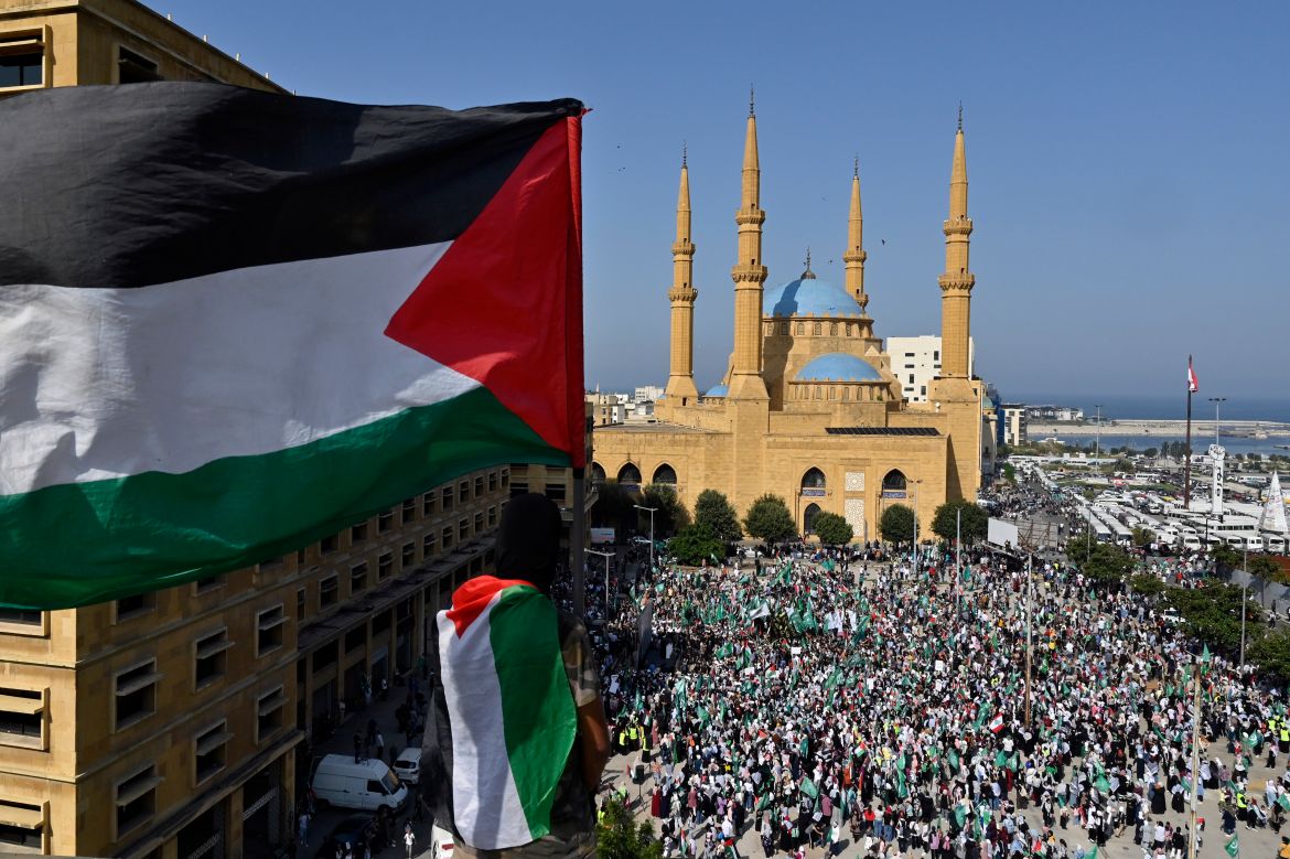 Supporters of the Islamic Group and Hamas movement carry Palestinian flags as they shout slogans during a protest in solidarity with the Palestinian people, amid the ongoing conflict between Israel and Hamas in the Gaza Strip, in downtown Beirut, Lebanon