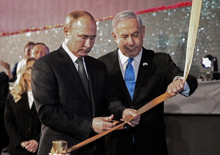 Israeli Prime Minister Benjamin Netanyahu (R) and Russian President Vladimir Putin cut the ribbon to unveil the Memorial Candle monument in Jerusalem on January 23, 2020 to commemorate the people of Leningrad during the Second World War Nazi siege on the city. (Photo by Amit SHABI / POOL / AFP)