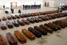 Coffins of victims from a shipwreck are seen in a hangar of the Lampedusa airport on October 5, 2013 [Antonio Parrinello/Reuters]