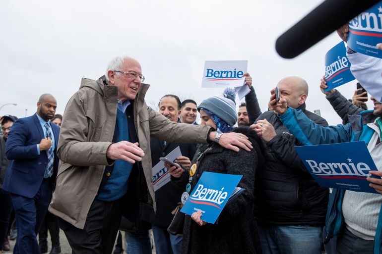 Bernie Sanders greets supporters holding "Bernie" signs