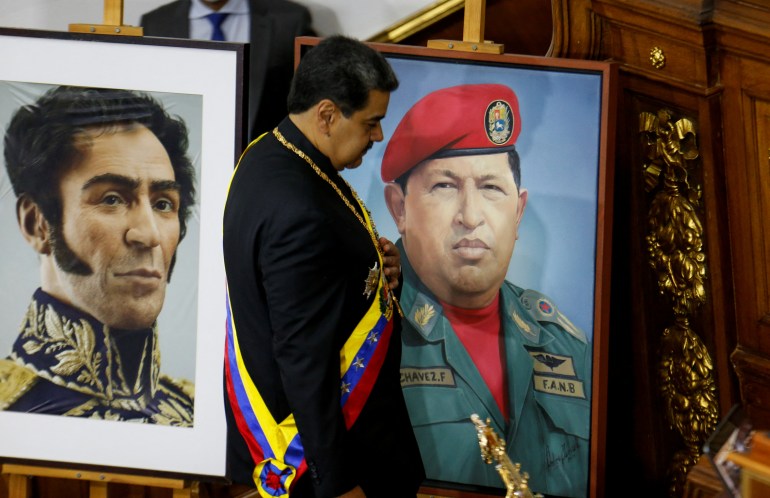 Venezuela's President Nicolas Maduro stands by the portrait of former President Hugo Chavez, as he attends a state of the nation address at the National Assembly, in Caracas, Venezuela January 12, 2023. REUTERS/Leonardo Fernandez Viloria