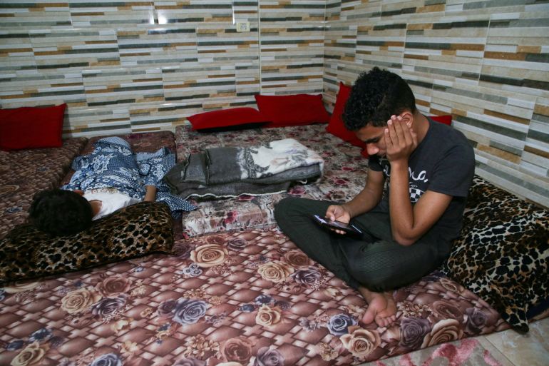 A Palestinian boy watches news on his phone at his house in Khan Younis in the southern Gaza