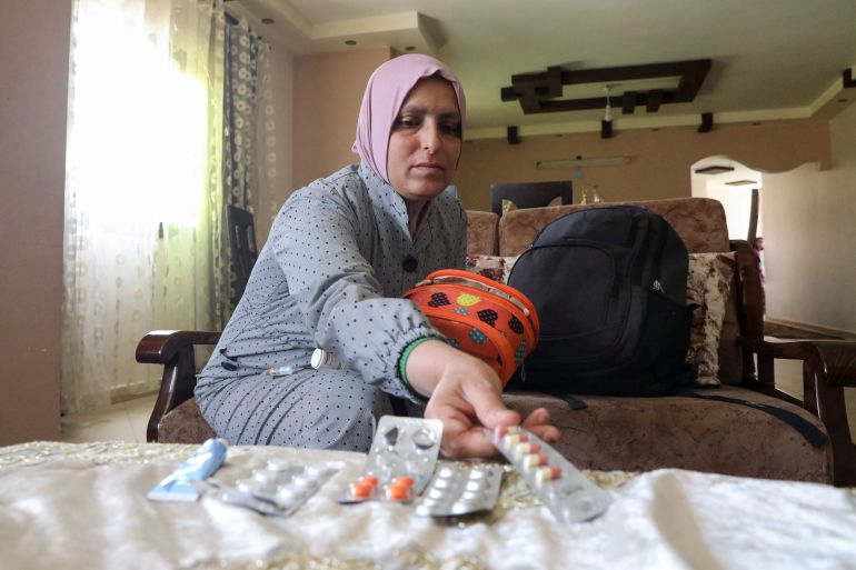 Dina El-Dhani, a Palestinian cancer patient who missed her treatment session at a hospital in Jerusalem as Israel has kept its crossings with Gaza closed amid Israel-Gaza fighting, displays her medications, in Gaza City May 12, 2023. REUTERS/Fadi Shana