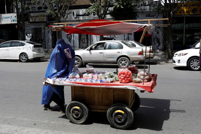 An Afghan woman pushes her cart in Kabul, Afghanistan, July 6, 2023. REUTERS/Ali Khara