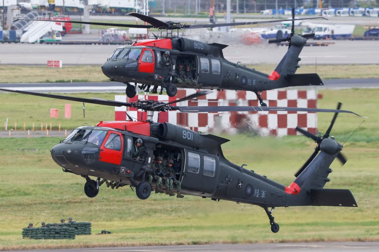 Two Black Hawk helicopters landing at Taiwan's international airport during military exercises