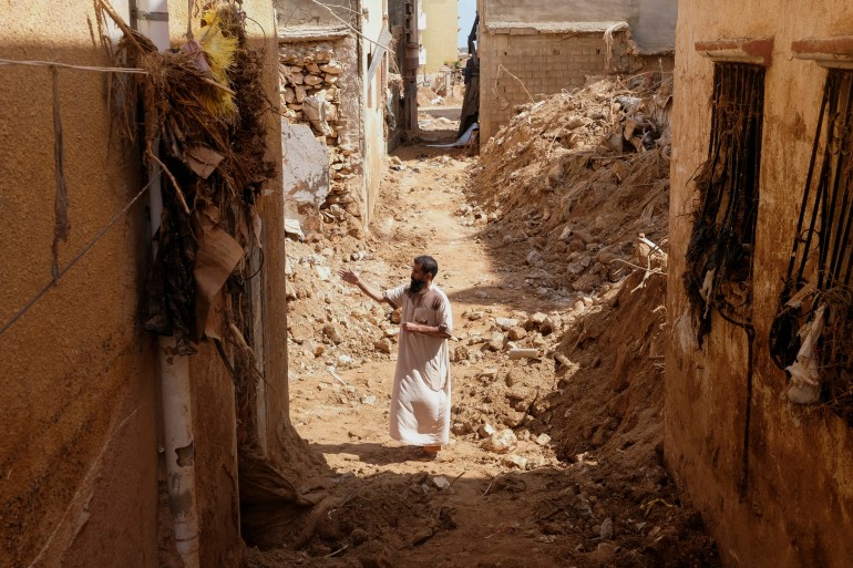 A man inspects damaged buildings, in the aftermath of a deadly storm and flooding that hit Libya, in Derna, Libya 