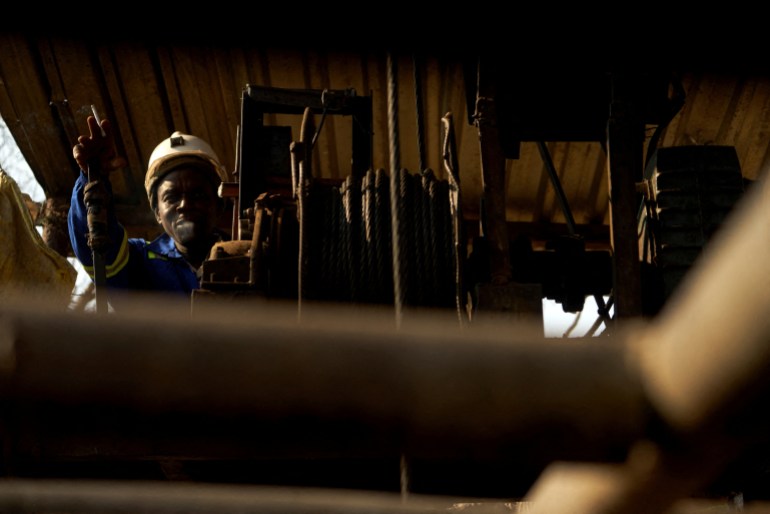 A miner operates a winch during a rescue and recovery operation after several miners were killed when a disused mining shaft collapsed near Chegutu, Zimbabwe