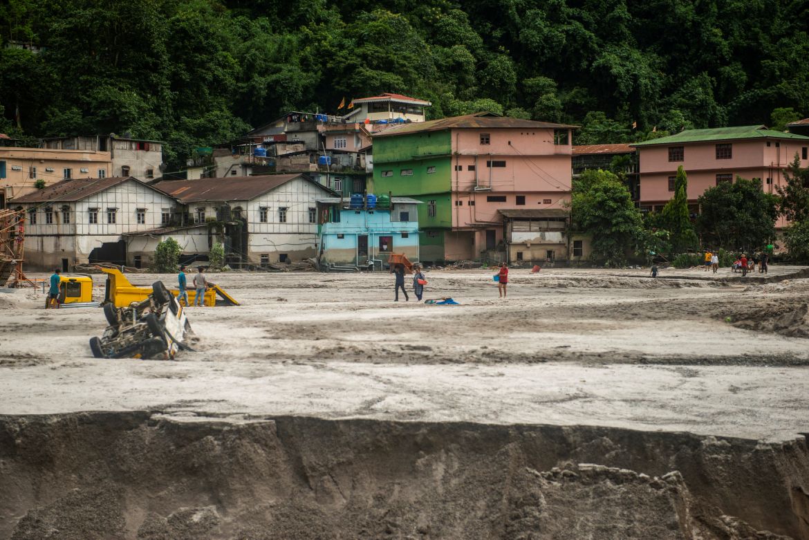 People walk along the area affected by the flood at Golitar