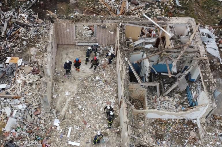 Rescues remove debris at a site of buildings of a local cafe and a grocery store, where at least 52 people were killed by a Russian missile strike