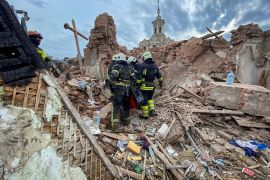 Rescues carry a bag with the body of 10-year-old boy released from debris at a site of a residential building damaged by a Russian missile strike in Kharkiv, Ukraine October 6, 2023.