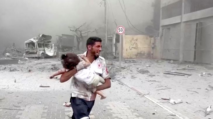 A medic runs as he carries an injured Palestinian child to ambulance in this screengrab taken from a video, in Gaza