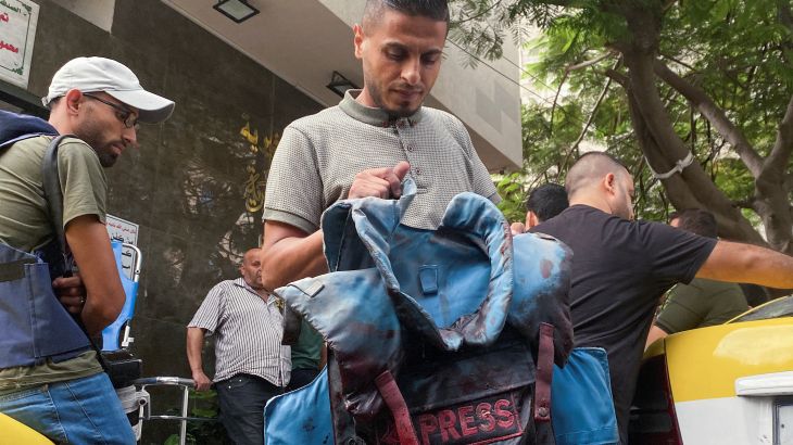 A man carries a blood-stained flak jacket belonging to Palestinian journalist Mohammed Soboh