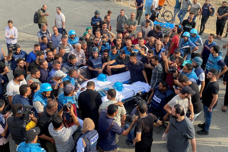 Mourners, including colleagues, carry the bodies of Palestinian journalists Mohammed Soboh and Saeed al-Taweel, who were killed when an Israeli missile hit a building while they were outside reporting, at a hospital in Gaza City.