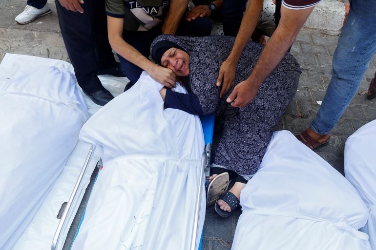 Um parente reage ao lado dos corpos de palestinos mortos em ataques israelenses, em um hospital na Cidade de Gaza
