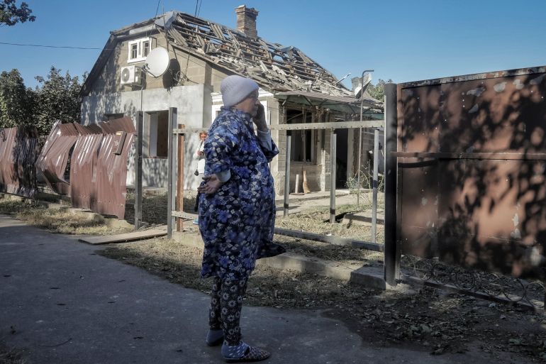 A woman standing outside a house damaged by a Russian drone in the town of Izmail.