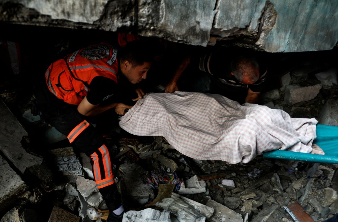 Rescuers recover a body from under the rubble