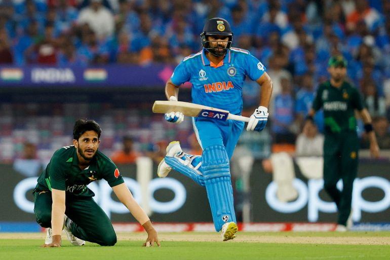 India's Rohit Sharma runs between the wickets as Pakistan's Hasan Ali looks on