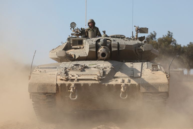 An Israeli soldier rides in a tank