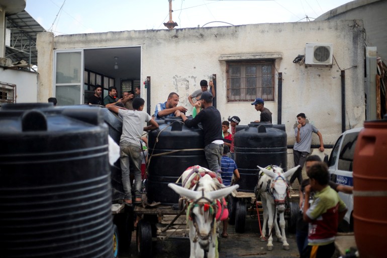 Palestinians collect water,