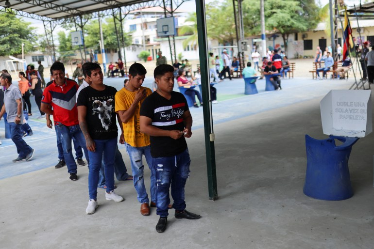 People queue to vote at a polling station during the presidential election, in Tosagua