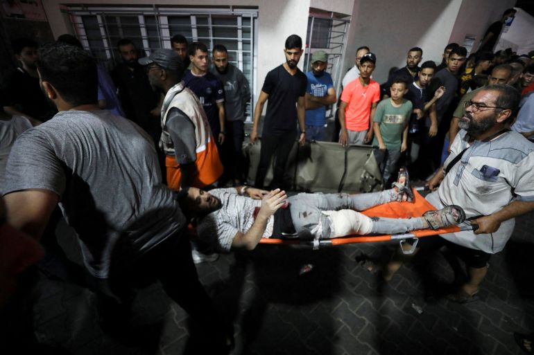 An injured person is assisted at Shifa Hospital after an Israeli air strike hit the nearby Al-Ahli Hospital