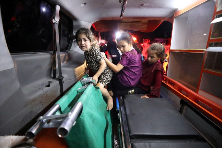 Children sit in the back of an ambulance at Shifa Hospital after an Israeli air strike hit the nearby Al-Ahli Hospital