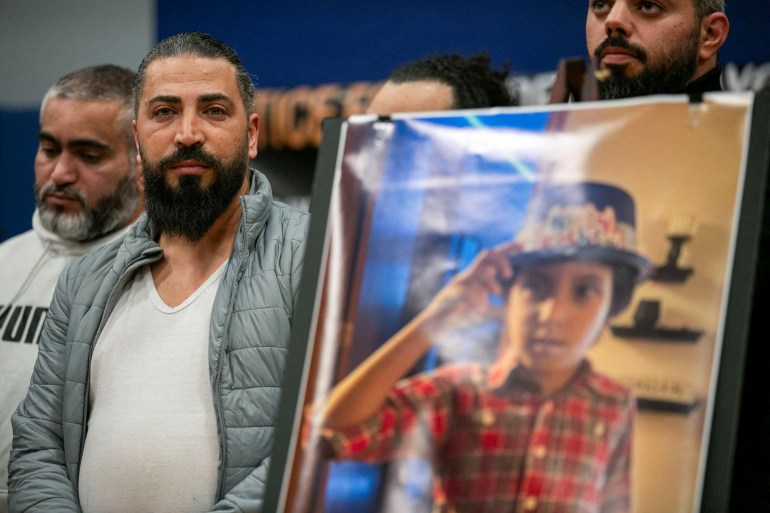 Father stands next to photo of Wadea Al-Fayoume