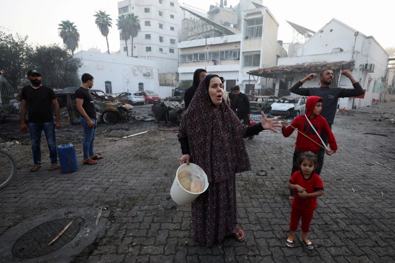 People react at the area of Al-Ahli hospital, where hundreds of Palestinians were killed in a blast