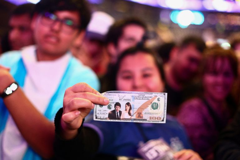 Una persona tiene in mano una finta banconota con il volto della candidata alla vicepresidenza Victoria Villarruel e del candidato alla presidenza Javier Milei