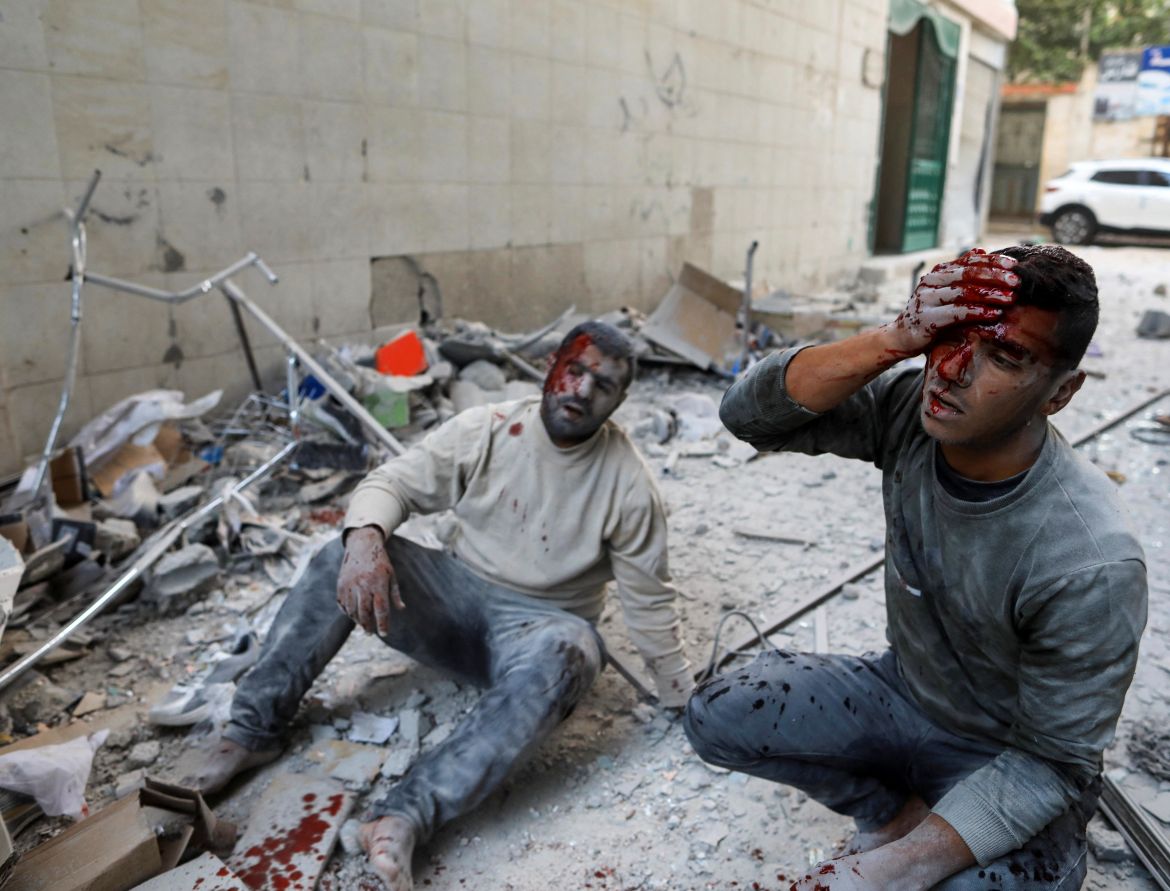 Wounded Palestinians react at the site of an Israeli strike in Khan Younis