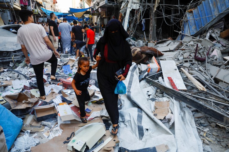 Palestinians walking through rubble