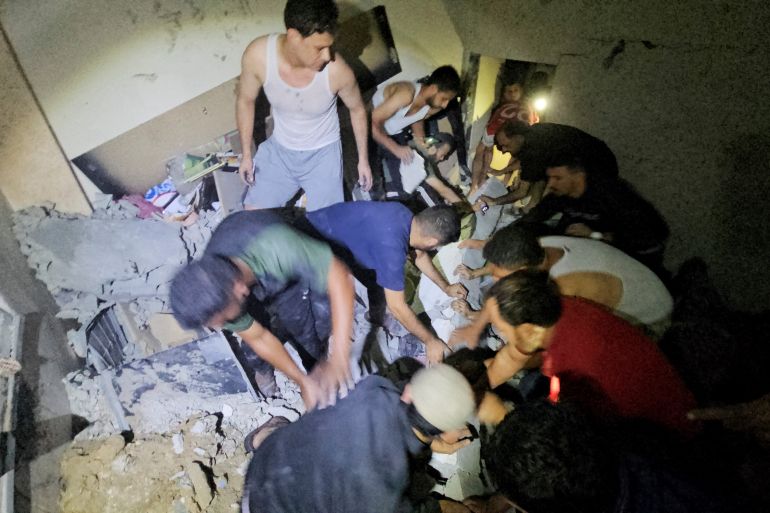 Palestinians work to rescue a boy trapped in the rubble following an Israeli strike on a house in Jabalia in the northern Gaza Strip, October 19, 2023