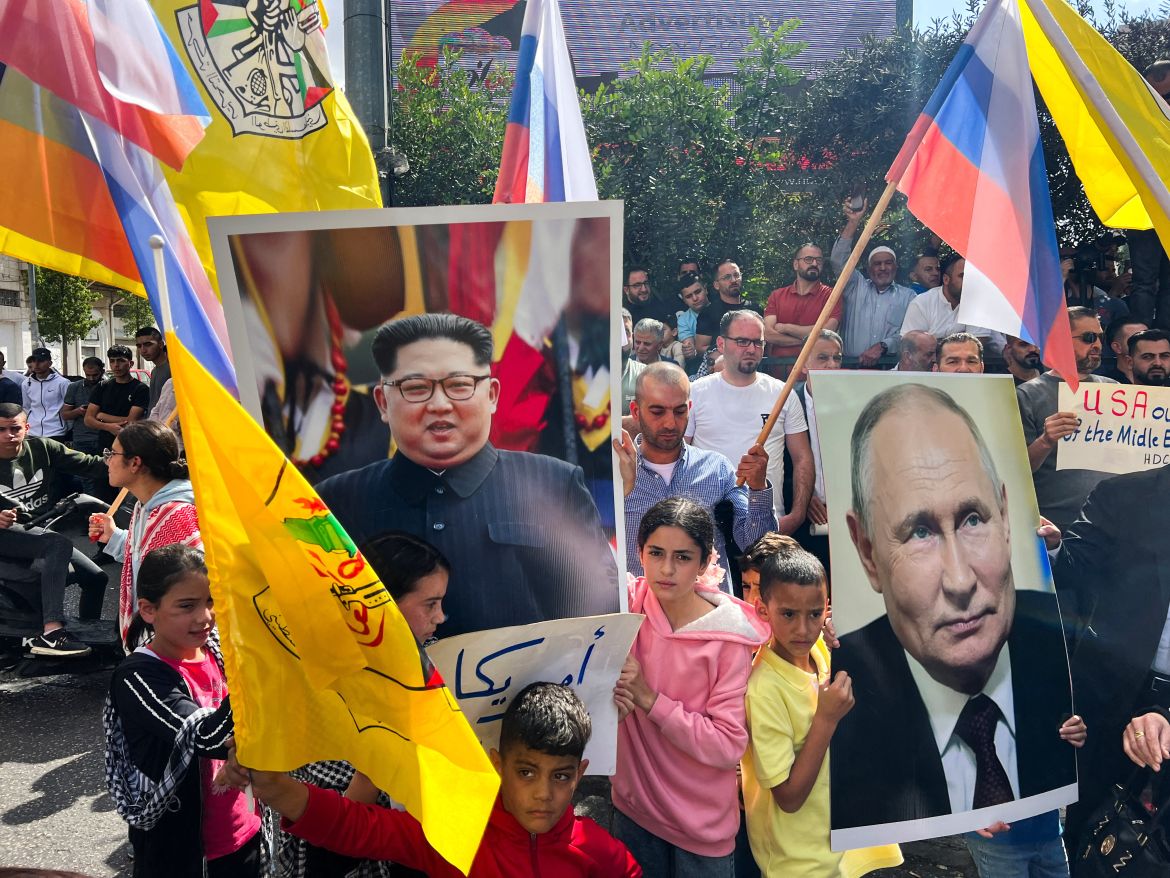 Palestinians hold pictures of the Russian President Vladimir Putin and North Korean leader Kim Jong-UN during a protest in support of the people of Gaza, as the conflict between Israel and Hamas continues, in Hebron in the Israeli-occupied West Bank
