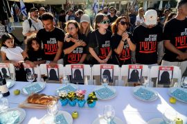 The families of Israelis who are missing or being held hostage stand by a set dinner table with empty chairs that symbolically represent hostages with families that are waiting for them to come home, following a deadly infiltration by Hamas gunmen from the Gaza Strip, in Tel Aviv, Israel October 20, 2023. REUTERS/Janis Laizans